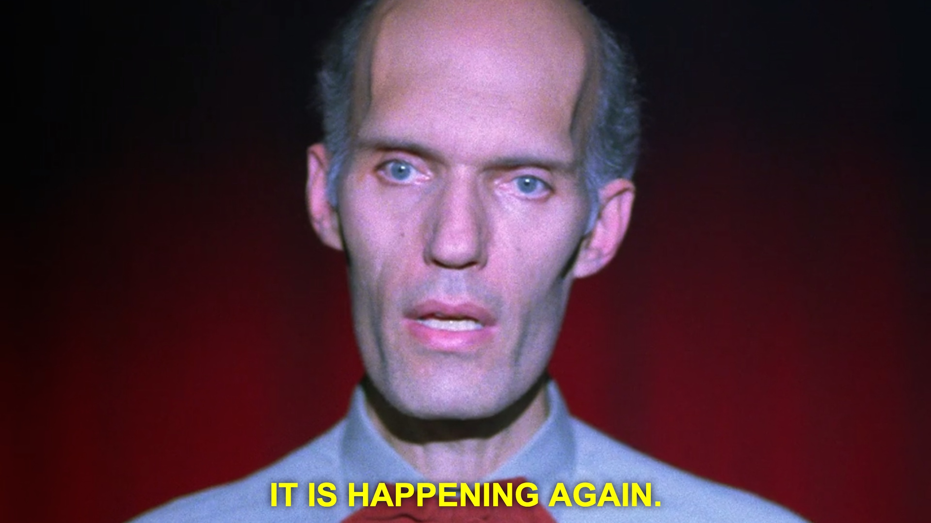 The Giant from Twin Peaks against a red curtain, with the subtitle &ldquo;It is happening again.&rdquo;